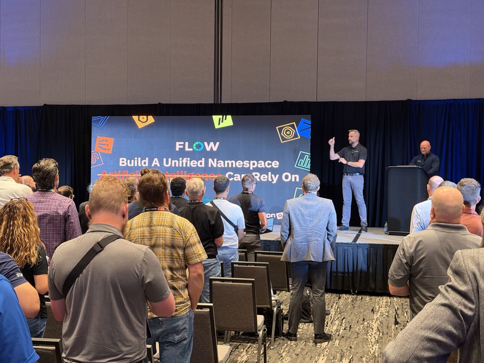 Jeff kicking off Flow's ICC 2026 talk Jeff presenting on stage in front of a Flow slide reading Build A Unified Namespace, with Artificial Intelligence struck through, Can Rely On